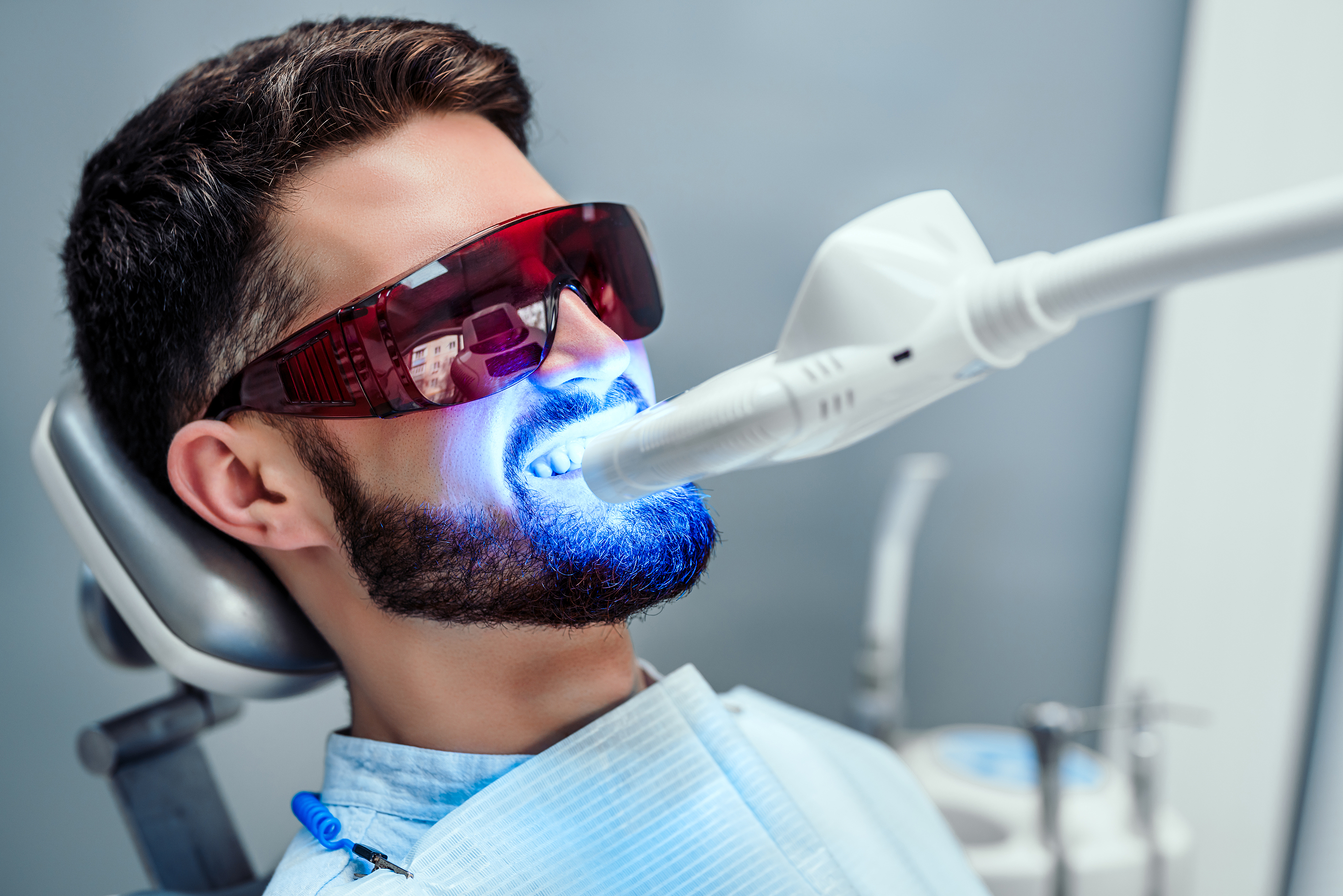 Close Up View Of Man Undergoing Laser Tooth Whitening Treatment Close up view of man undergoing laser tooth whitening treatment to remove stains and discoloration.